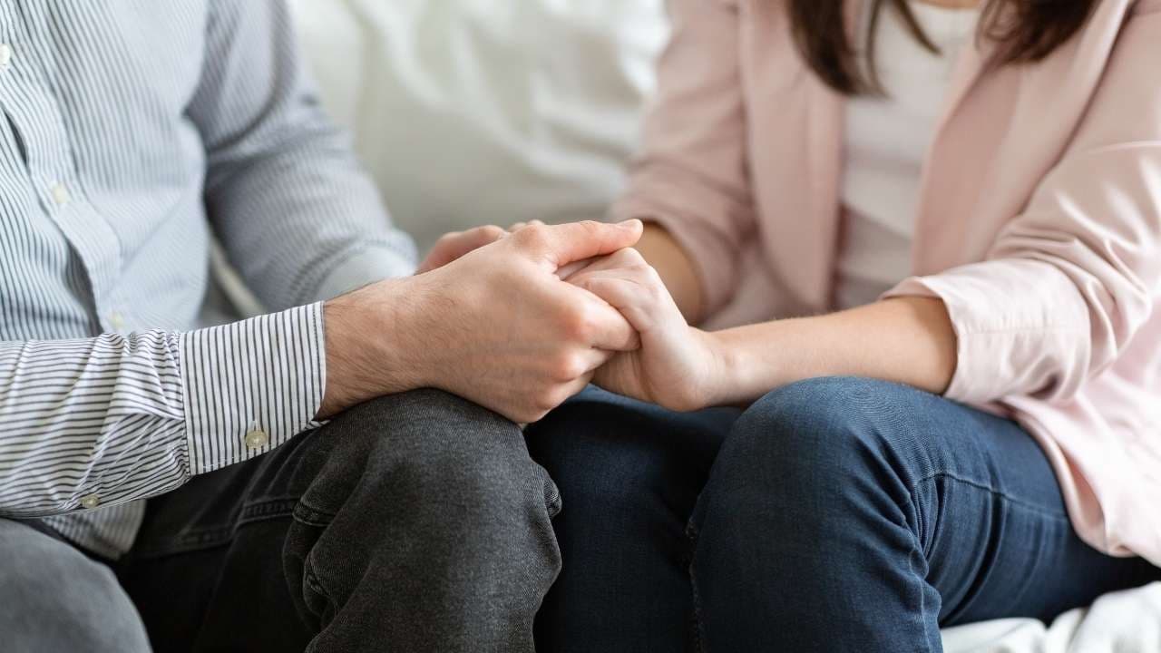 Mãos a apoiar outra pessoa durante uma sessão de terapia